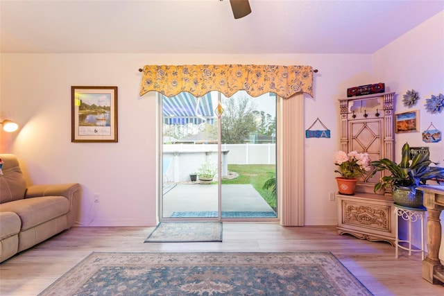 interior space with baseboards, a ceiling fan, and wood finished floors