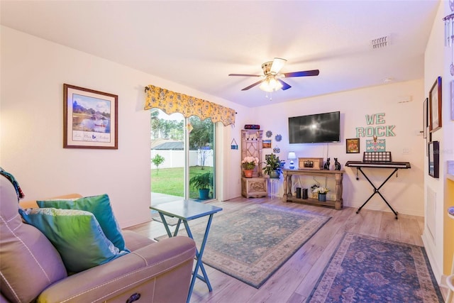 living room with a ceiling fan, baseboards, visible vents, and wood finished floors