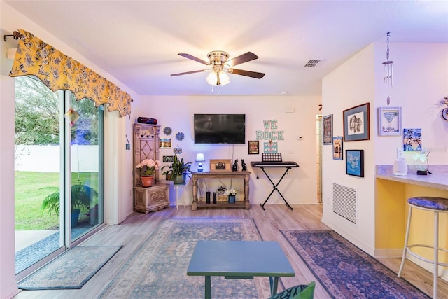 interior space featuring baseboards, wood finished floors, visible vents, and a ceiling fan