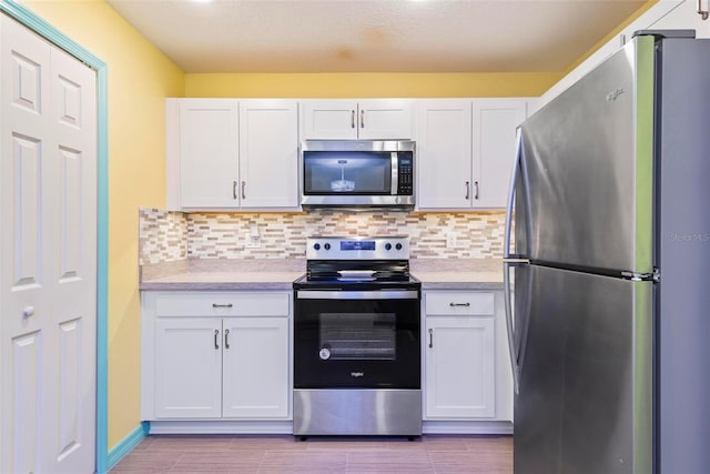 kitchen with stainless steel appliances, white cabinets, and light countertops