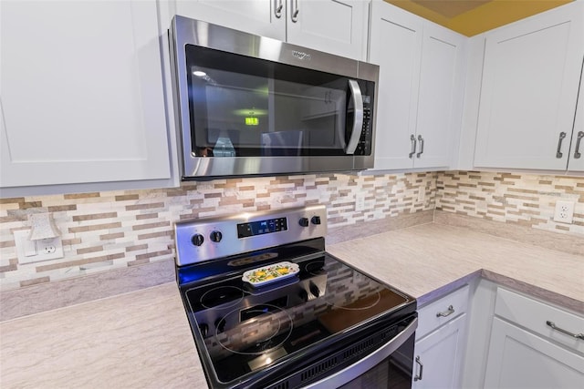 kitchen with white cabinets, decorative backsplash, stainless steel appliances, and light countertops