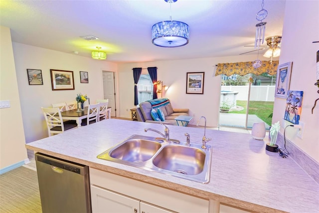 kitchen featuring a sink, white cabinets, open floor plan, light countertops, and dishwasher