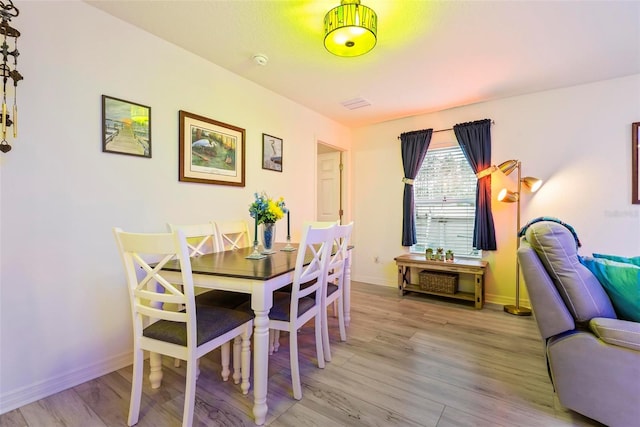 dining room featuring baseboards and light wood finished floors