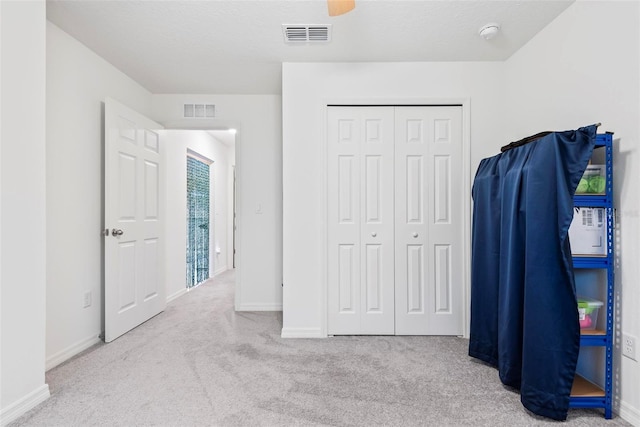 carpeted bedroom with a ceiling fan, baseboards, visible vents, and a closet