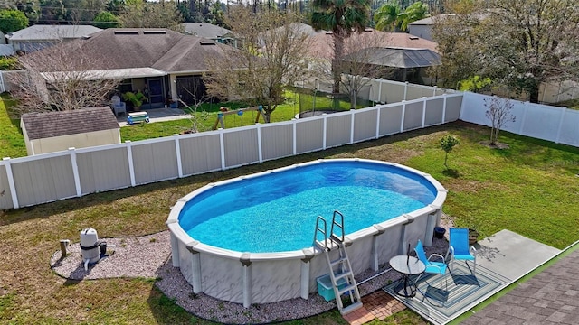 view of pool featuring a fenced in pool, an outbuilding, a fenced backyard, and a yard