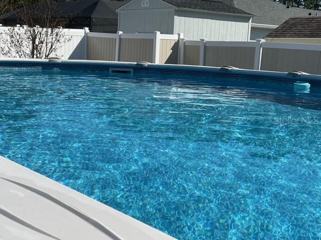 view of pool with a fenced in pool and fence