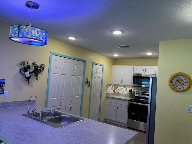 8 Smoke Tree Pl, Palm Coast, FL 32164 - kitchen featuring stainless steel appliances, a sink, white cabinets, decorative backsplash, and recessed lighting