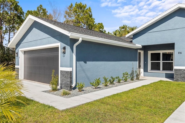 view of home's exterior with stone siding, a yard, an attached garage, and stucco siding