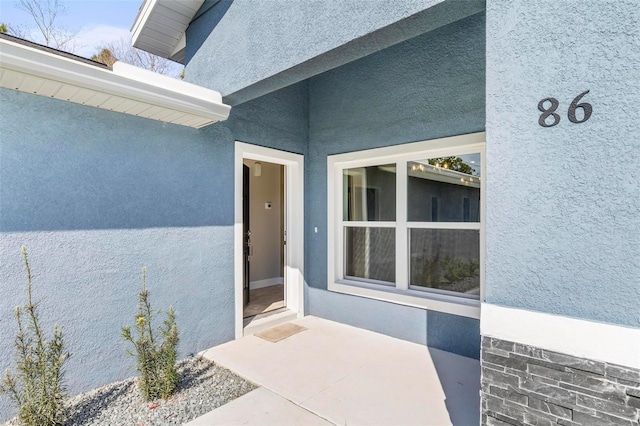 doorway to property featuring stucco siding