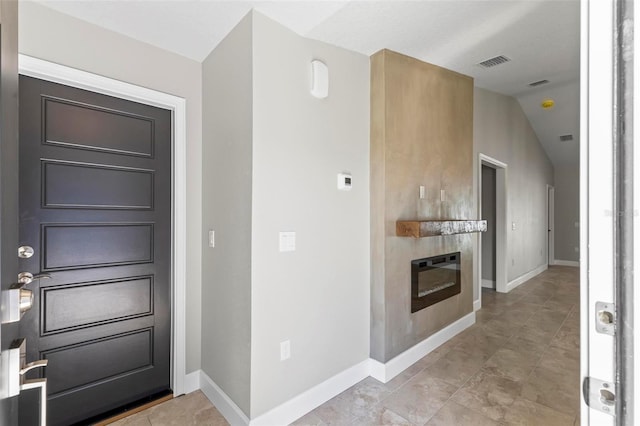 interior space with lofted ceiling, baseboards, and visible vents