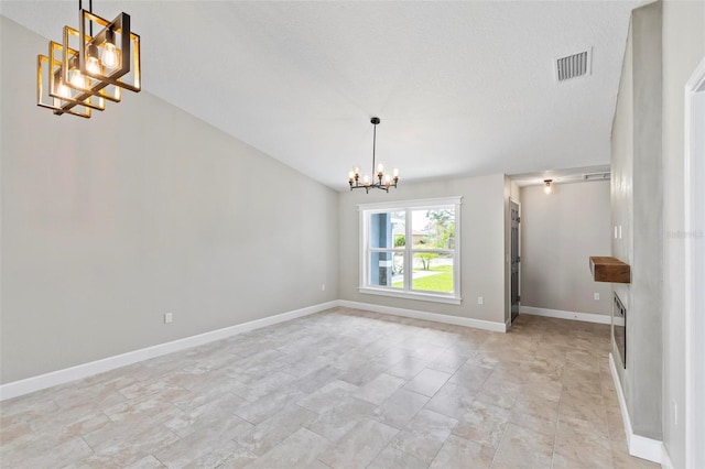 interior space featuring lofted ceiling, visible vents, a notable chandelier, and baseboards