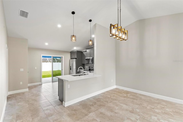 kitchen featuring visible vents, vaulted ceiling, stainless steel appliances, light countertops, and a sink