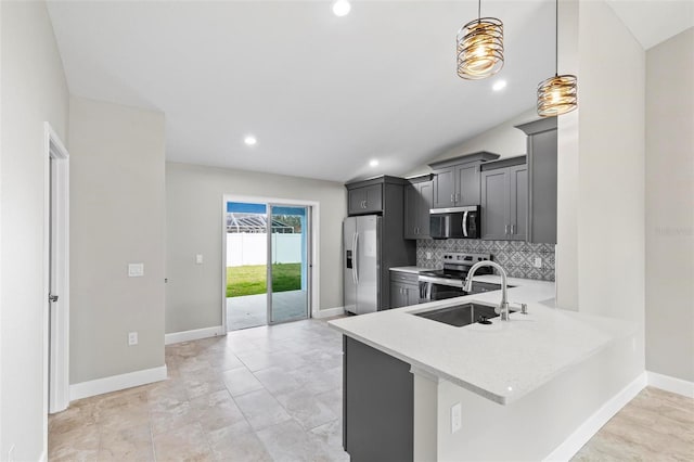 kitchen with lofted ceiling, tasteful backsplash, appliances with stainless steel finishes, and a sink