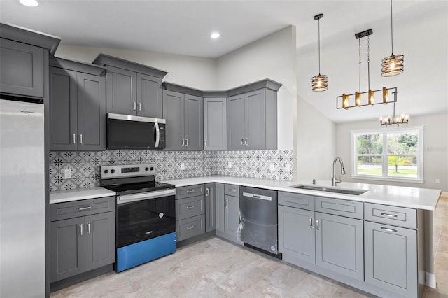 kitchen featuring stainless steel appliances, a peninsula, a sink, light countertops, and gray cabinets