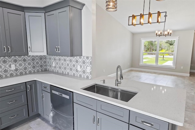 kitchen with pendant lighting, tasteful backsplash, gray cabinets, stainless steel dishwasher, and a sink