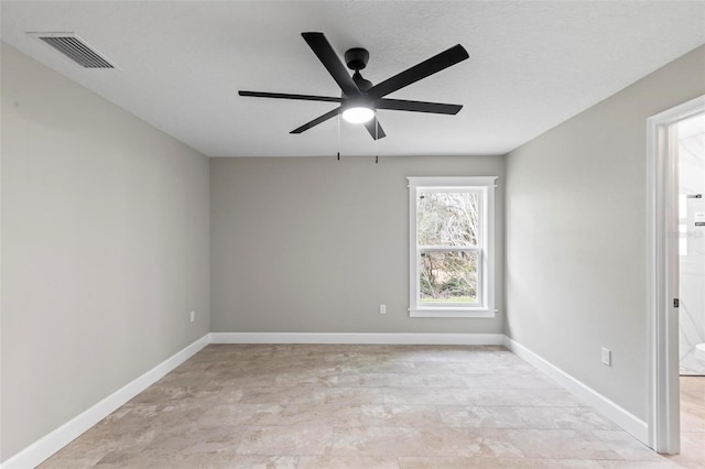 empty room featuring a ceiling fan, visible vents, and baseboards