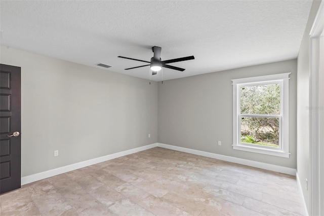 empty room with a ceiling fan, baseboards, visible vents, and a textured ceiling