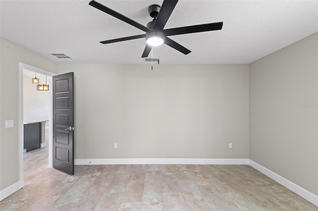 spare room featuring visible vents, baseboards, ceiling fan, and a textured ceiling