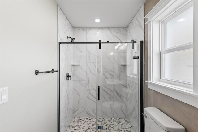 bathroom featuring toilet, a marble finish shower, and recessed lighting