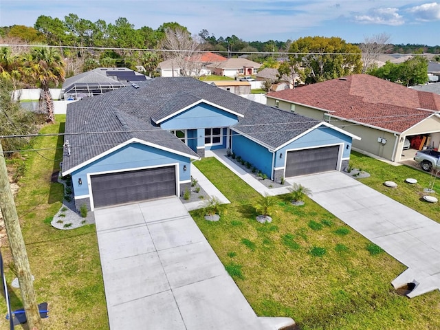 view of front of house featuring roof with shingles, a front yard, a garage, a residential view, and driveway