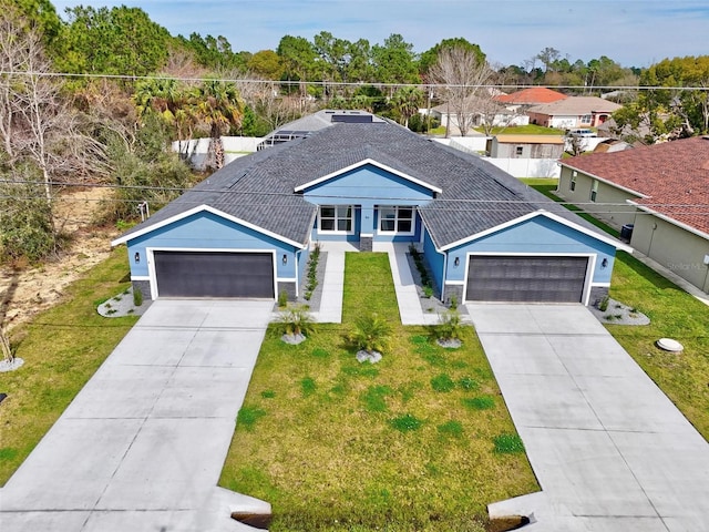 view of front of home with driveway, a shingled roof, and a front yard