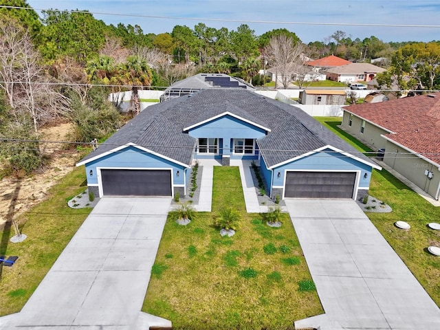 view of front of house featuring a shingled roof, fence, and a front yard