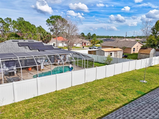 view of pool with a lawn, a fenced backyard, a residential view, and a lanai