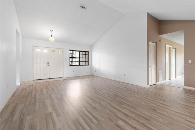 unfurnished living room featuring high vaulted ceiling, visible vents, and light wood-style flooring