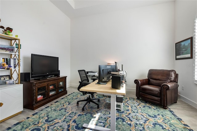 home office with baseboards and wood finished floors