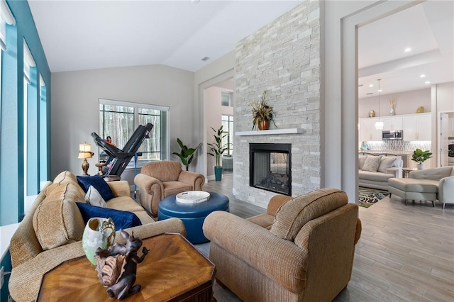 living area with lofted ceiling, a fireplace, recessed lighting, and wood finished floors