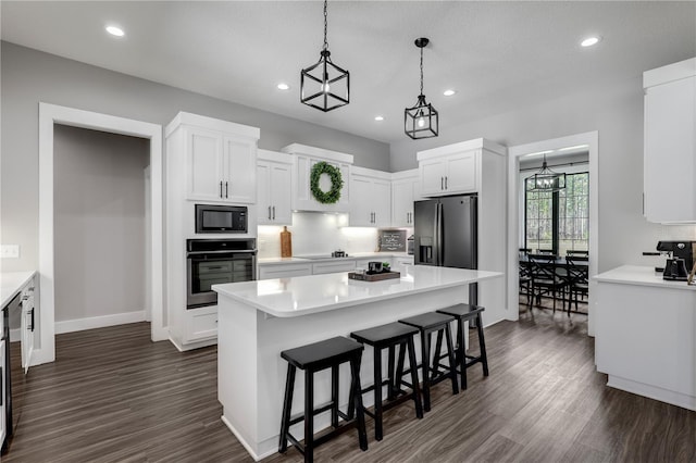 kitchen featuring black appliances, a kitchen island, white cabinetry, and light countertops