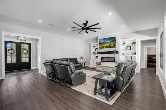 living area with recessed lighting, dark wood-type flooring, visible vents, french doors, and a brick fireplace