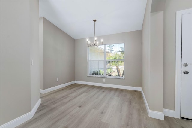 unfurnished dining area featuring baseboards, a notable chandelier, lofted ceiling, and light wood-style floors