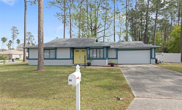 view of front of house with a front yard, an attached garage, fence, and concrete driveway