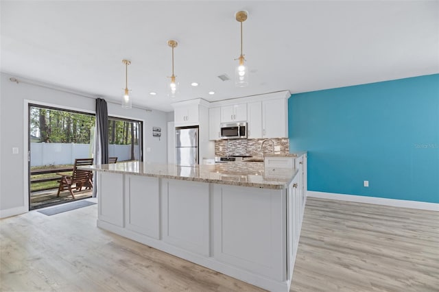 kitchen featuring light stone counters, pendant lighting, stainless steel appliances, decorative backsplash, and white cabinetry