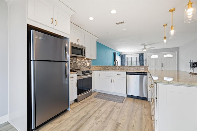 kitchen with appliances with stainless steel finishes, visible vents, white cabinetry, and a peninsula