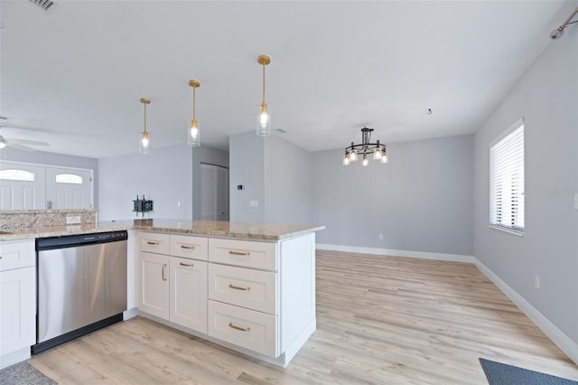 kitchen with light stone counters, white cabinetry, open floor plan, stainless steel dishwasher, and decorative light fixtures