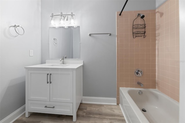 bathroom featuring baseboards, shower / washtub combination, wood finished floors, and vanity