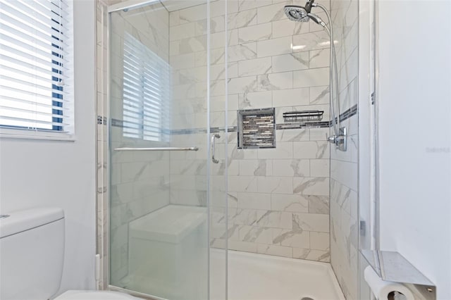 bathroom with a shower stall and toilet