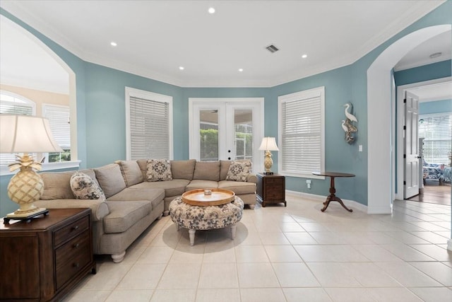 living room with french doors, a healthy amount of sunlight, light tile patterned flooring, and ornamental molding