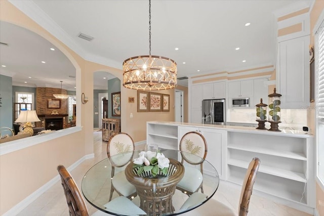 dining space featuring visible vents, recessed lighting, a fireplace, arched walkways, and crown molding