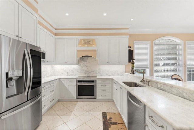 kitchen featuring a peninsula, a sink, ornamental molding, stainless steel appliances, and backsplash