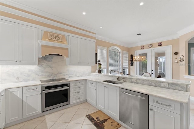 kitchen featuring tasteful backsplash, crown molding, a peninsula, stainless steel appliances, and a sink