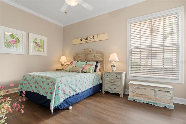 bedroom featuring ceiling fan, baseboards, wood finished floors, and crown molding