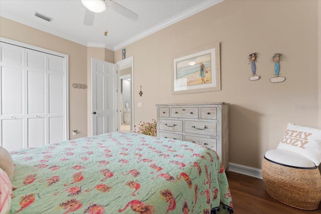 bedroom featuring visible vents, ornamental molding, a closet, baseboards, and dark wood-style flooring