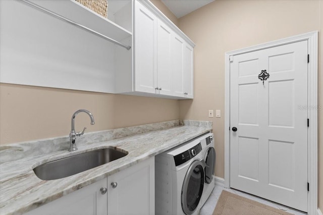 laundry area featuring a sink, cabinet space, and washing machine and clothes dryer