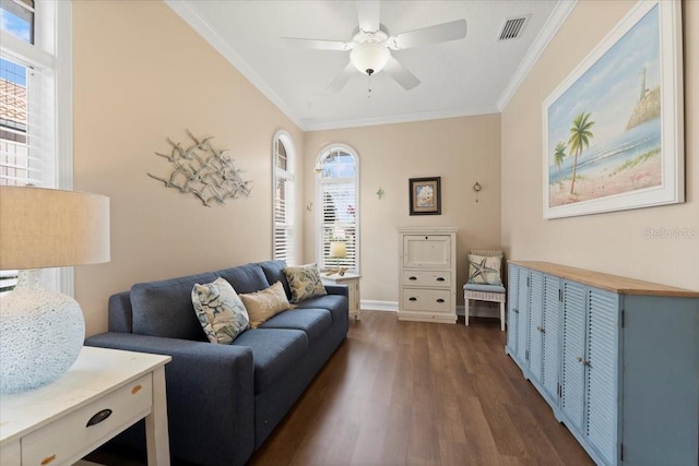 living area featuring visible vents, a healthy amount of sunlight, dark wood-style floors, and crown molding