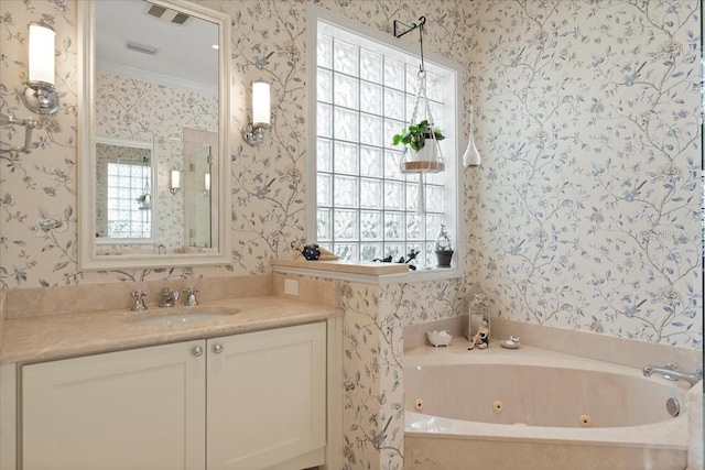 bathroom featuring crown molding, a tub with jets, vanity, and wallpapered walls