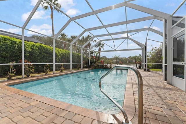 pool featuring glass enclosure and a patio