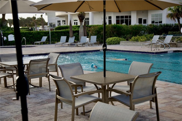 community pool featuring a patio area and fence